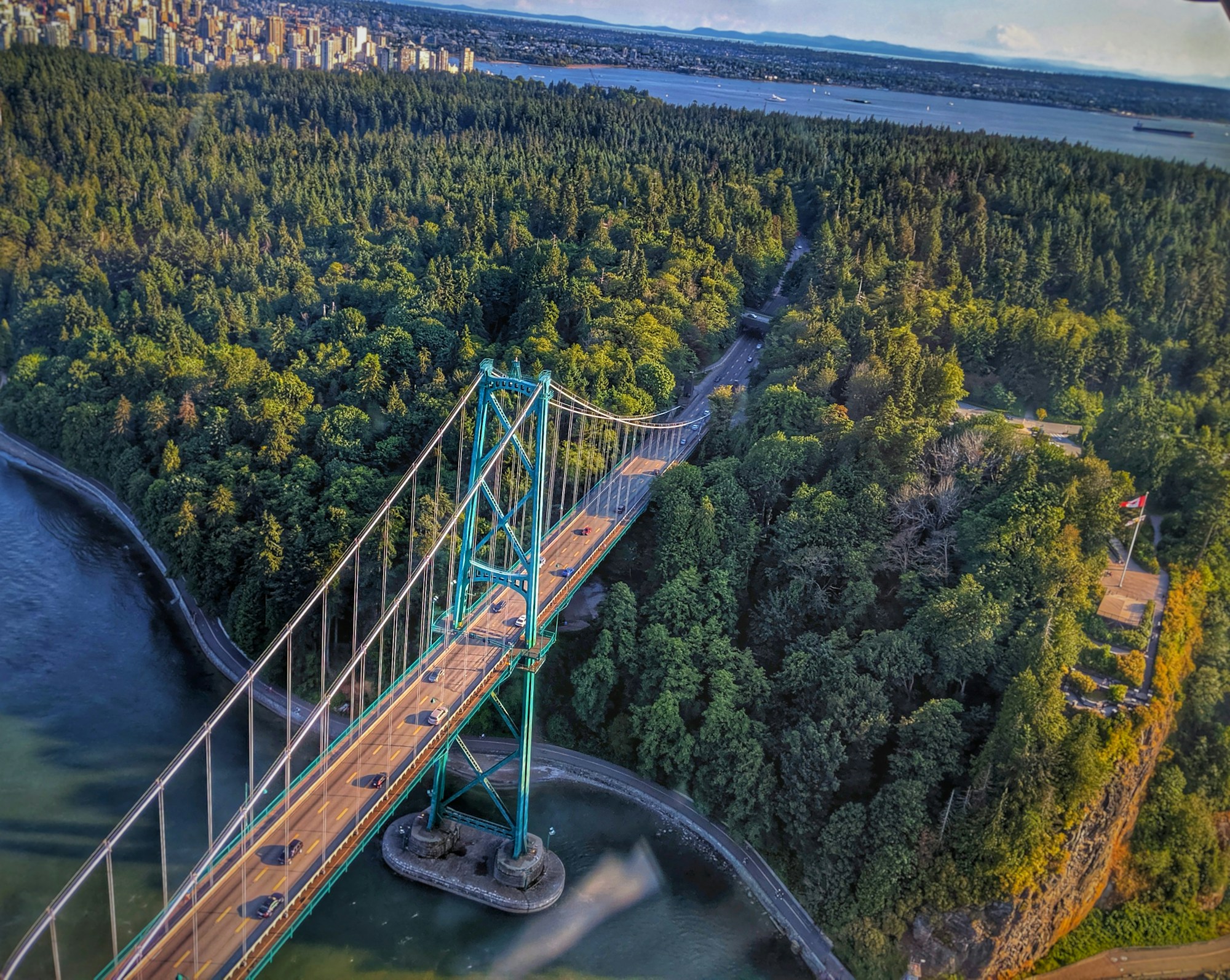 Aerial view of Lions Gate Bridge beside the forest of Stanley Park in Vancouver
